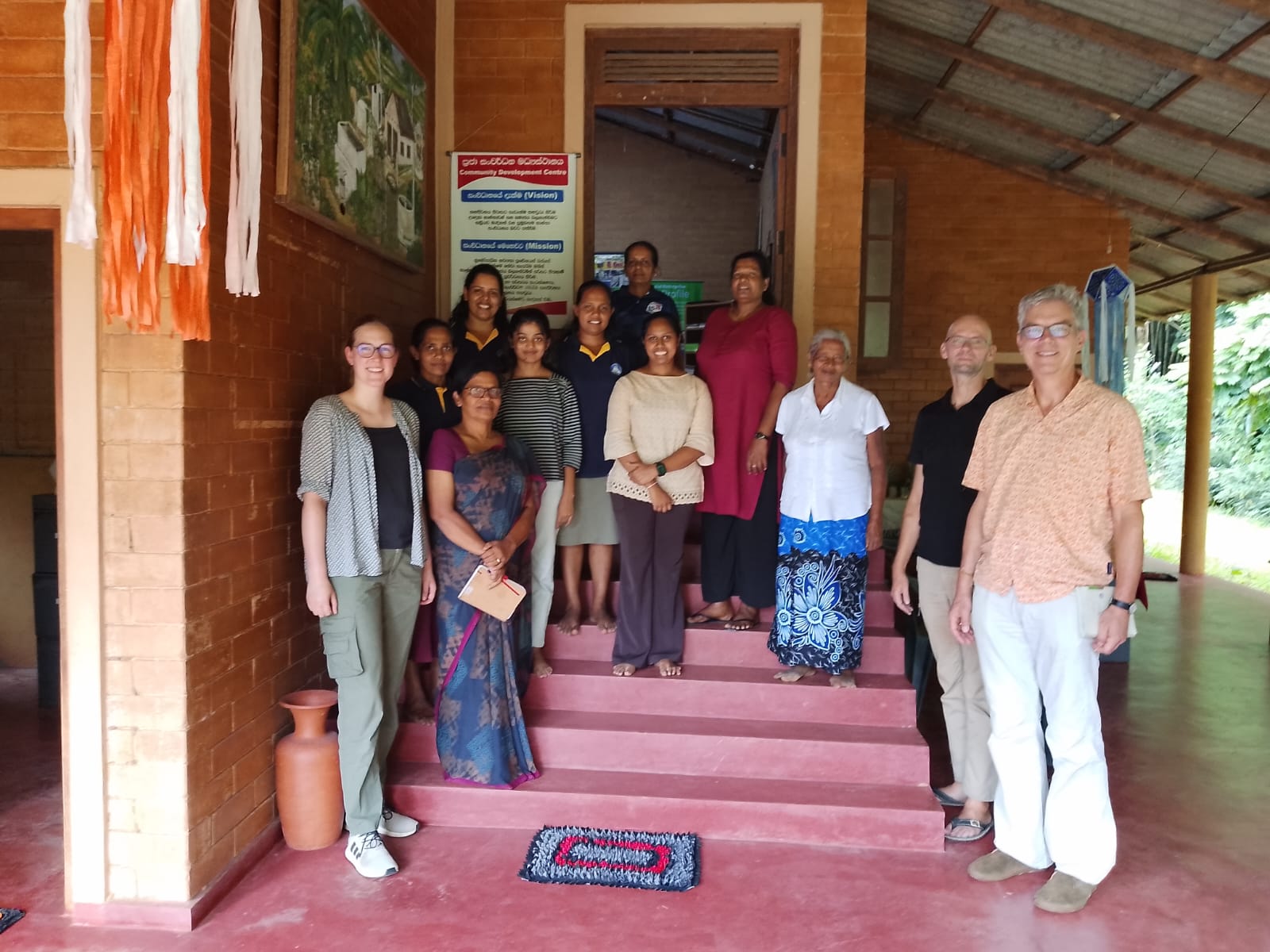 German visitors from LOAM standing with CDC staff and community members at the Community Development Centre
