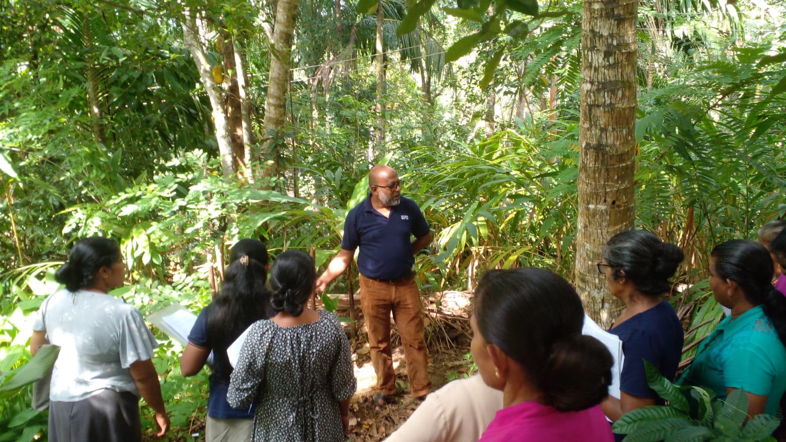CDC participants walking through a home garden during LOAM organic farming and PGS practical training