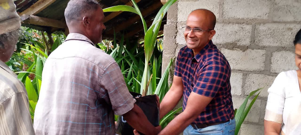 Community members receiving coconut seedlings in Dumbara Gama and Geradigala